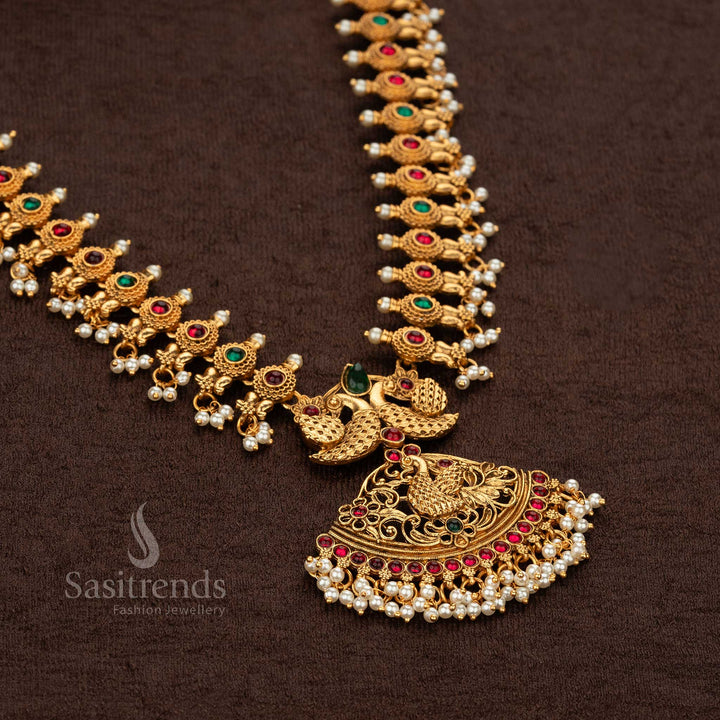 Elegant matte gold-plated temple peacock long haram necklace featuring ruby and green stones, designed for festive traditional occasions - Sasitrends