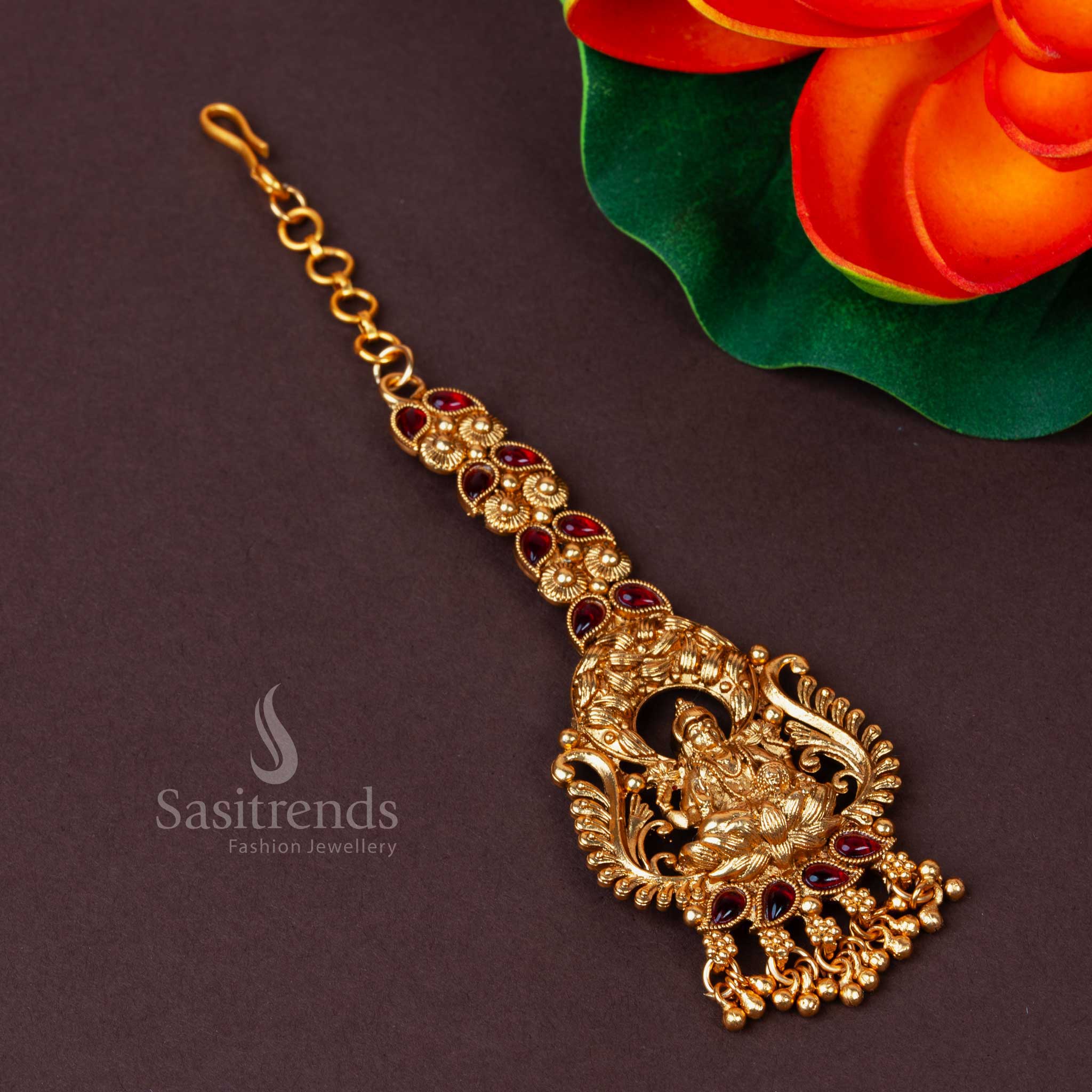 Exquisite Traditional Lakshmi Motif Maang Tikka in Matte Gold Plating, Adorned with American Diamond (AD) Stones and Lustrous Ruby Bead Drops - Sasitrends