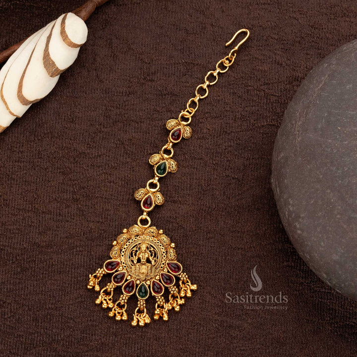 Ruby and green dual-tone matte gold plated maang tikka featuring a Lakshmi motif with pearl hangings - Sasitrends