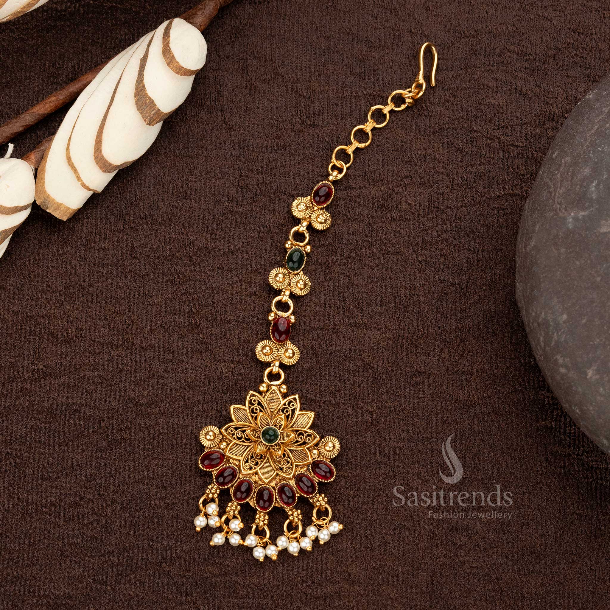 Ruby green matte gold plated maang tikka with intricate floral design and pearls - Sasitrends