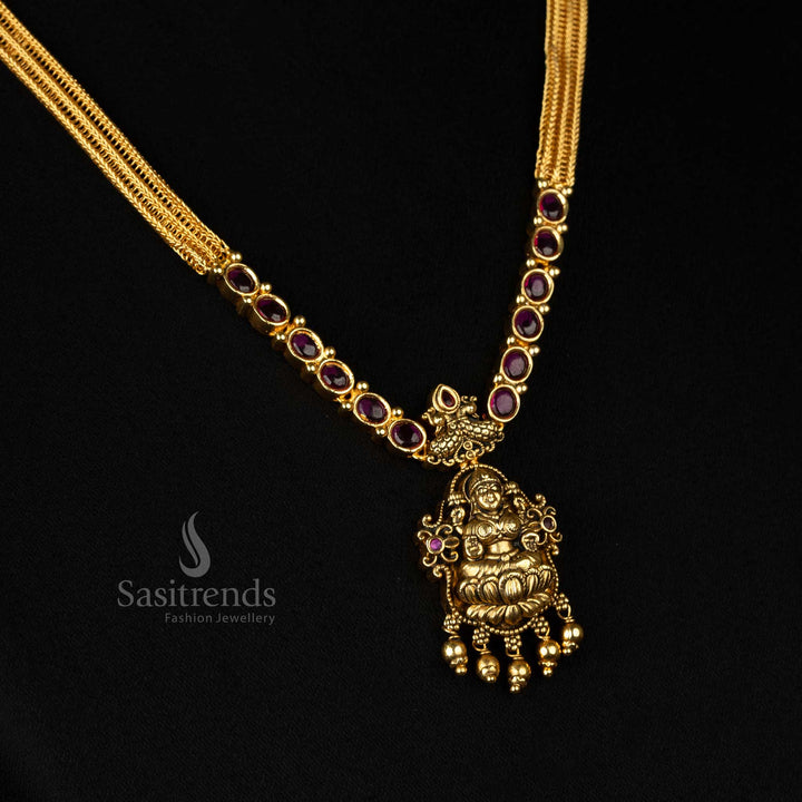 Royal matte gold plated temple necklace set featuring an artistic Goddess Lakshmi pendant, elegant peacock design, and striking ruby stone embroidery- Sasitrends