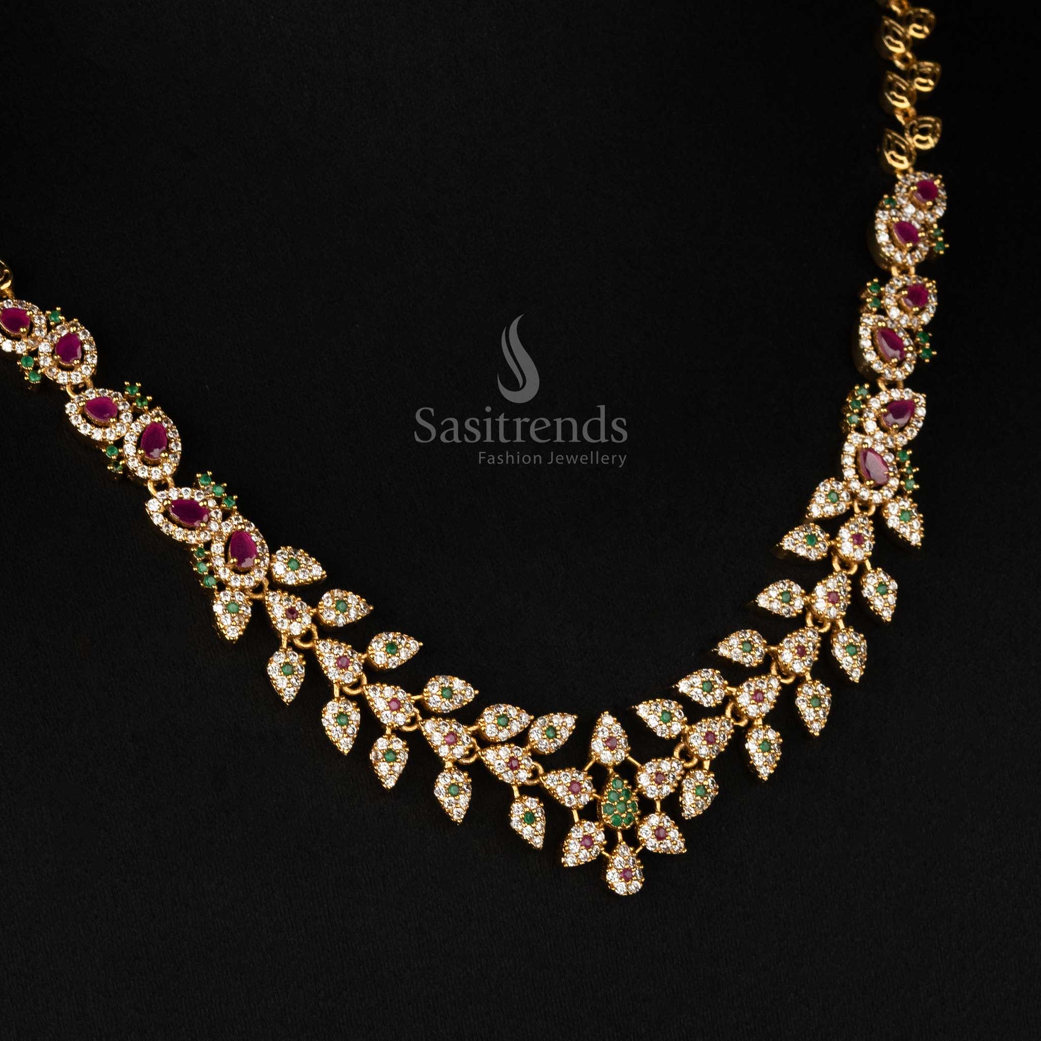 Ethnic matte gold plated multi-color temple jewellery set featuring an intricate leaf motif, floral tilak design, and dazzling AD stones - Sasitrends