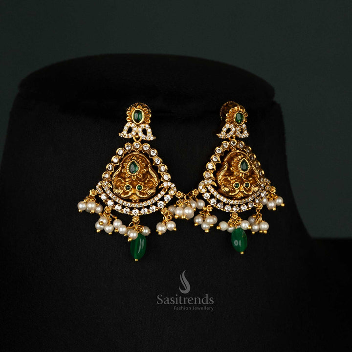 Traditional earrings set with green stones, a peacock-inspired motif, and matte gold-plated cascading pearls - Sasitrends