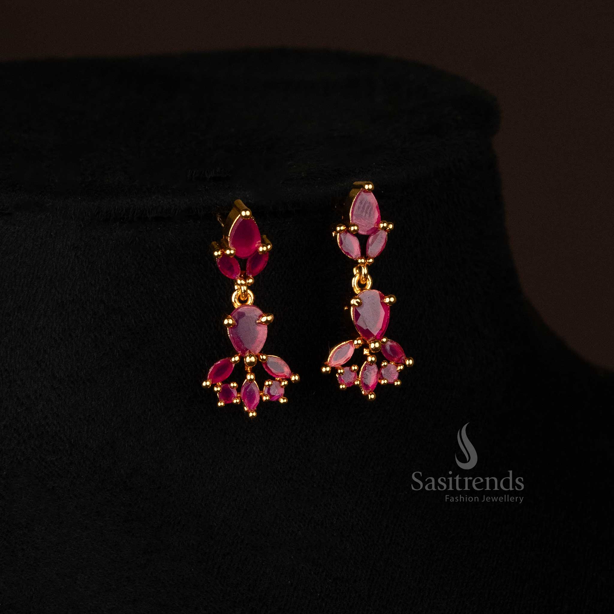 Model wearing micro gold-plated Earrings with ruby color stones and waterdrop motifs for a traditional look