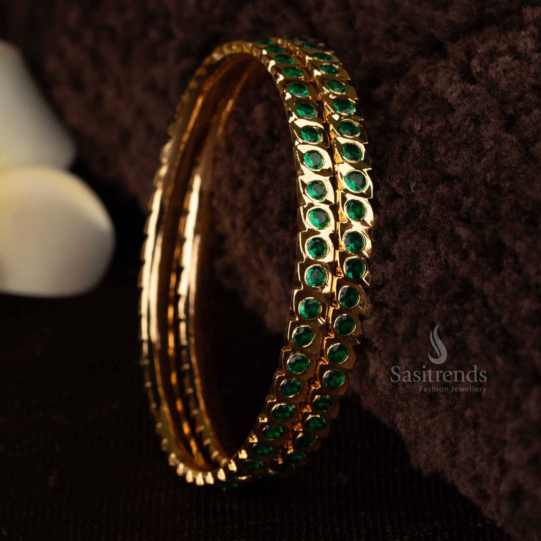 Exquisite gold-plated bangles adorned with stunning green AD stones, featuring intricate micro designs for a luxurious and elegant look - Sasitrends