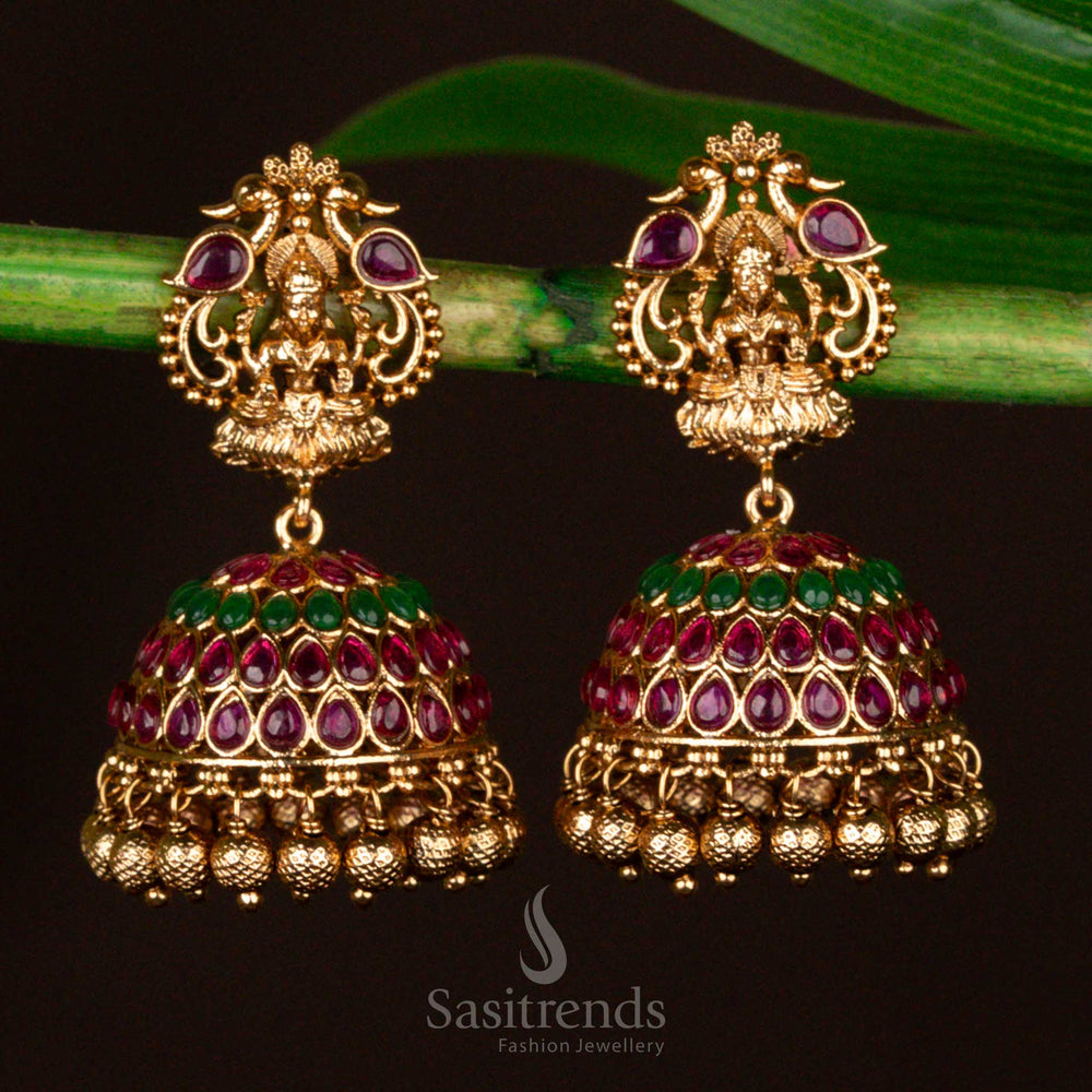 Majestic and exquisitely designed ruby-green temple Lakshmi bridal jhumka earrings, finely matte gold plated and featuring intricate craftsmanship - Sasitrends