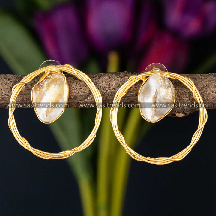 Chic twisted gold hoop earrings with a lustrous Mother of Pearl centerpiece