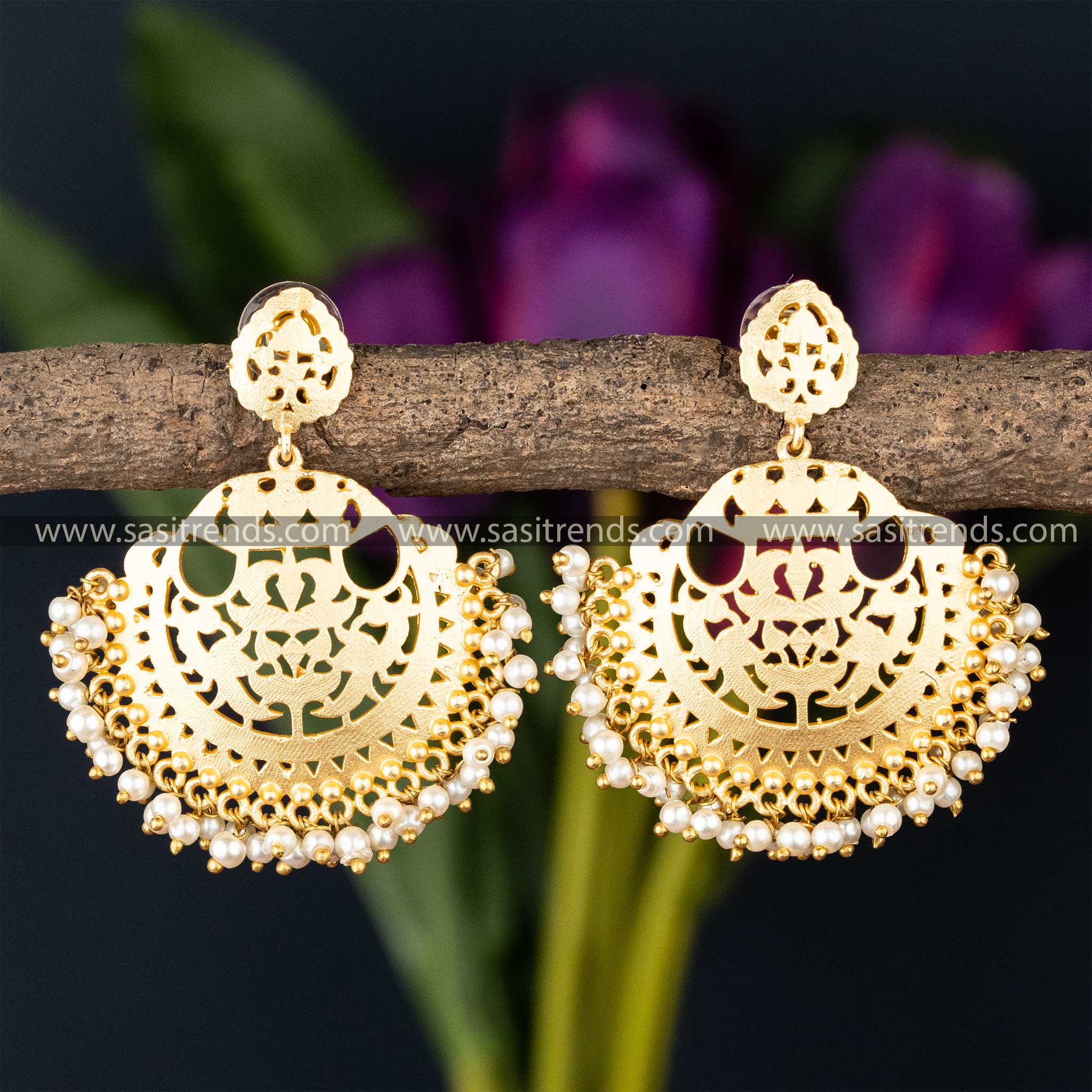 Ornate golden filigree earrings with pearl embellishments, combining traditional craftsmanship with modern design