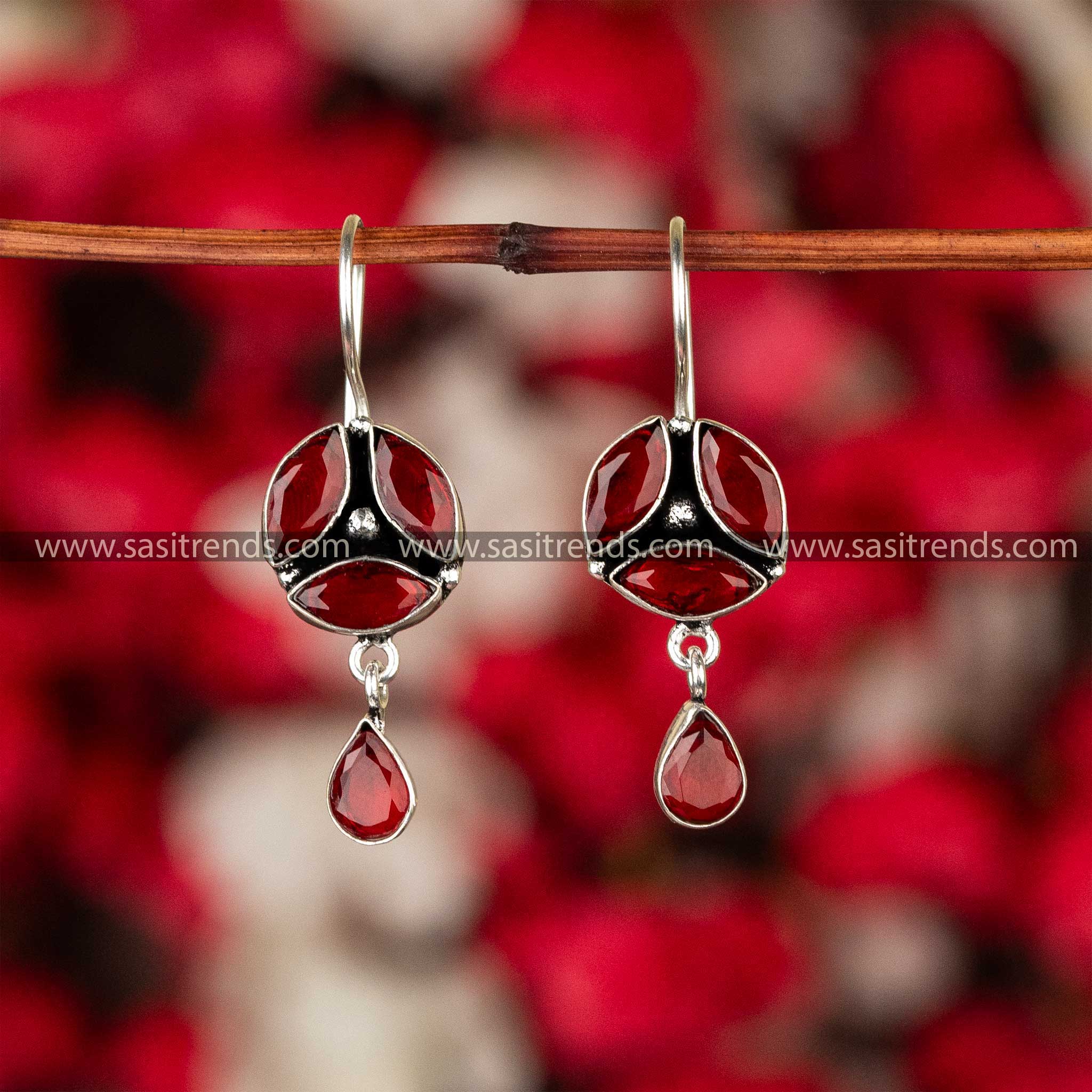 Ruby red stone-studded oxidised German silver earrings with elegant drop design