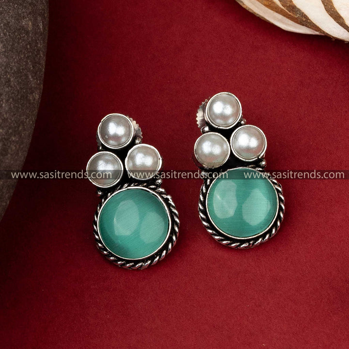 Timeless oxidized silver earrings with a prominent green monalisa stone encircled by a trio of elegant pearls