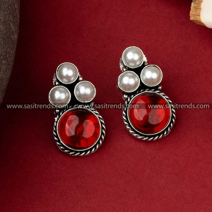 Stylish oxidized silver earrings featuring a trio of pearls with a bold red monalisa stone to accentuate any look