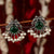 Vintage-style oxidised peacock earrings with an emerald center stone and pearl accents