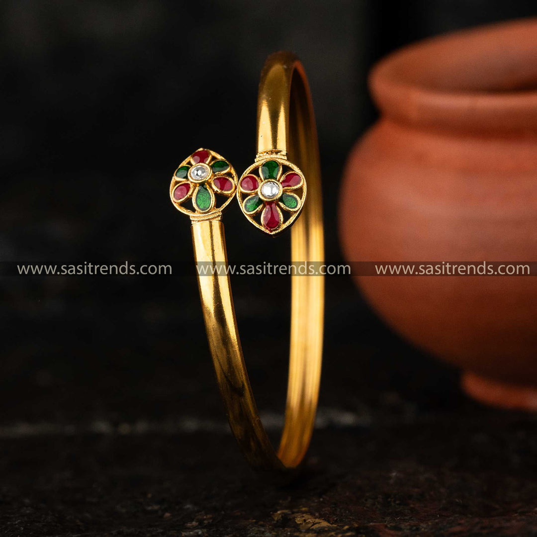 Elegant matte gold-plated brass kada bangle featuring a flower water drop motif with AD Kundan stone and colorful enamel details.