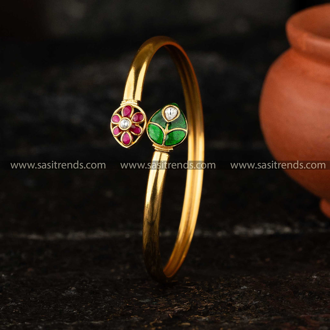 Elegant matte gold Kundan kada bangle with red and green floral enamel detailing, perfect for traditional and modern styles.