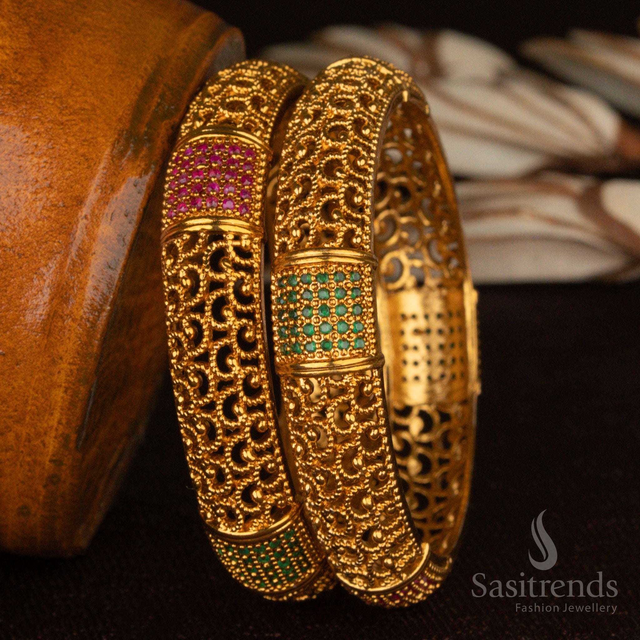 Grand matte gold-plated temple bangles, embedded with ruby-green stones and dazzling AD embellishments, featuring fine filigree cutwork for a regal ethnic look - Sasitrends