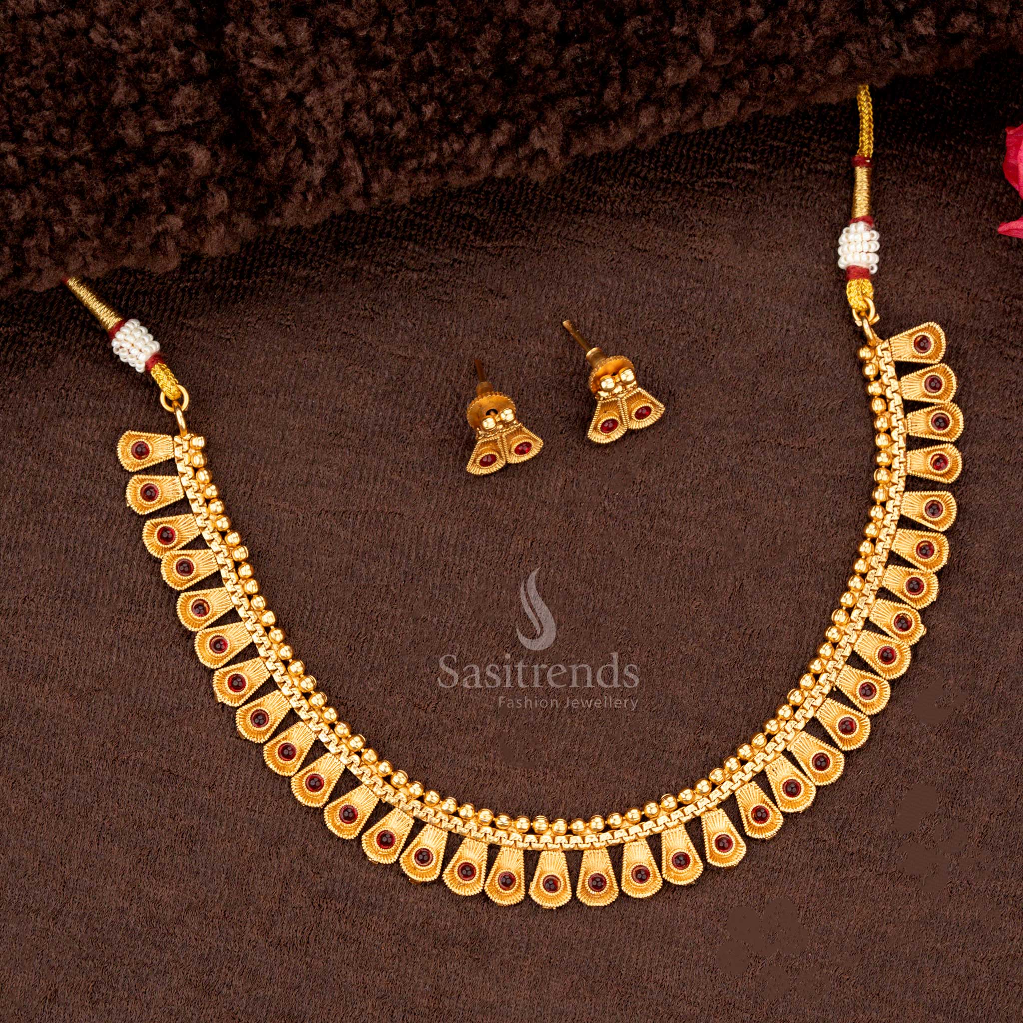 Elegant ruby-accented tapered teardrop motif jewellery set in matte gold - Sasitrends