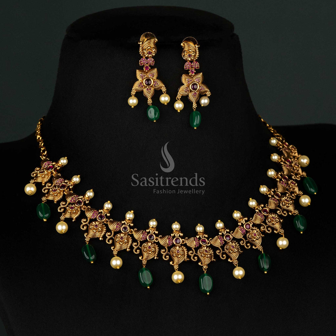 Exquisite temple jewellery set in matte gold with mango flower motifs, ruby stones, and green bead embellishments - Sasitrends