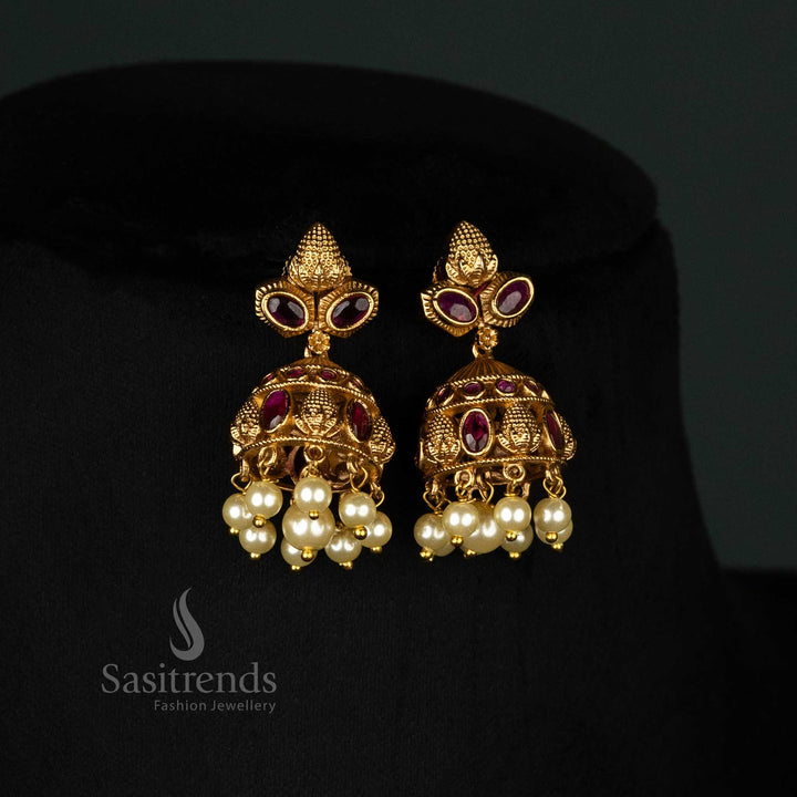 Exquisite temple bridal jewellery set with a matte gold finish, sparkling ruby stones, pearls, and ornate jhumka earrings - Sasitrends