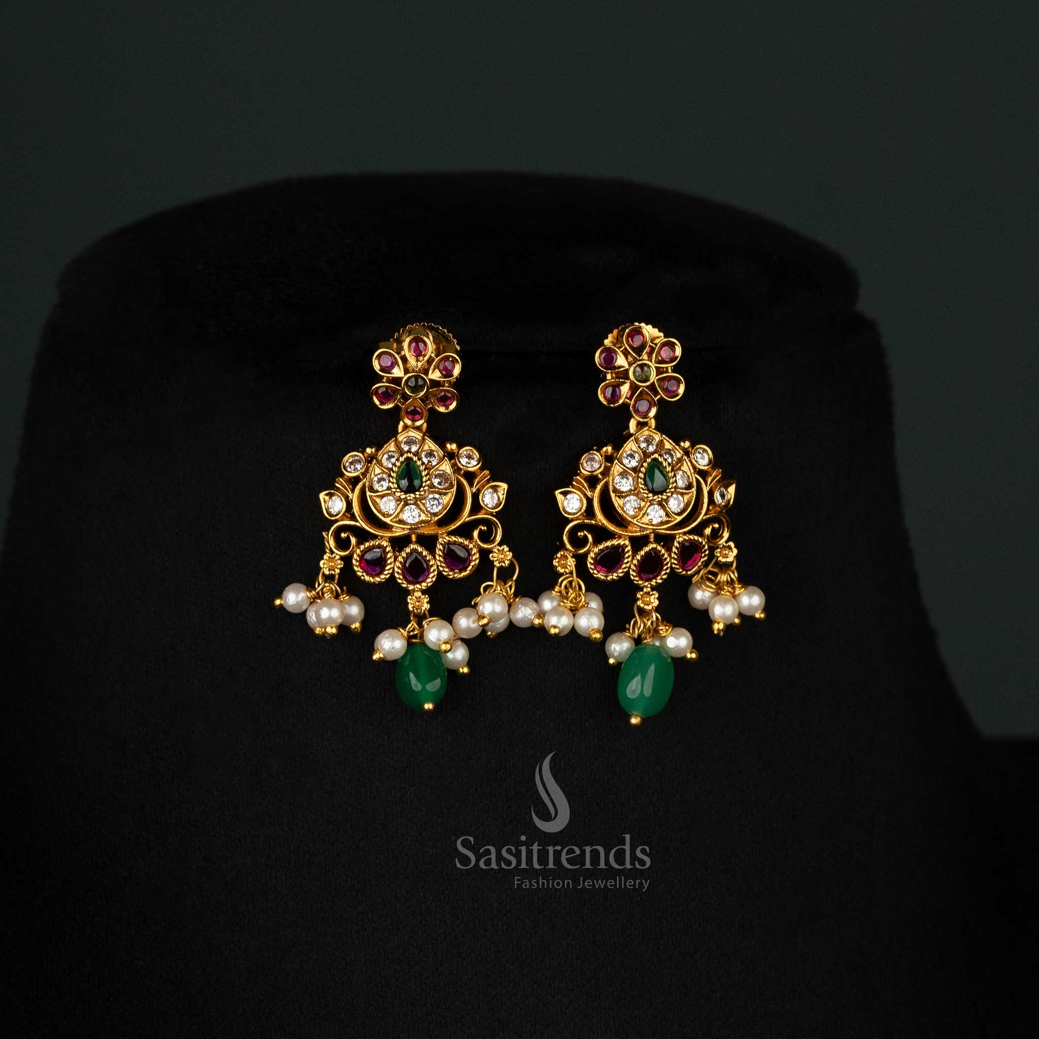 Artistic matte-finish gold Earrings set with ruby-green stones, floral embellishments, and a traditional design - Sasitrends