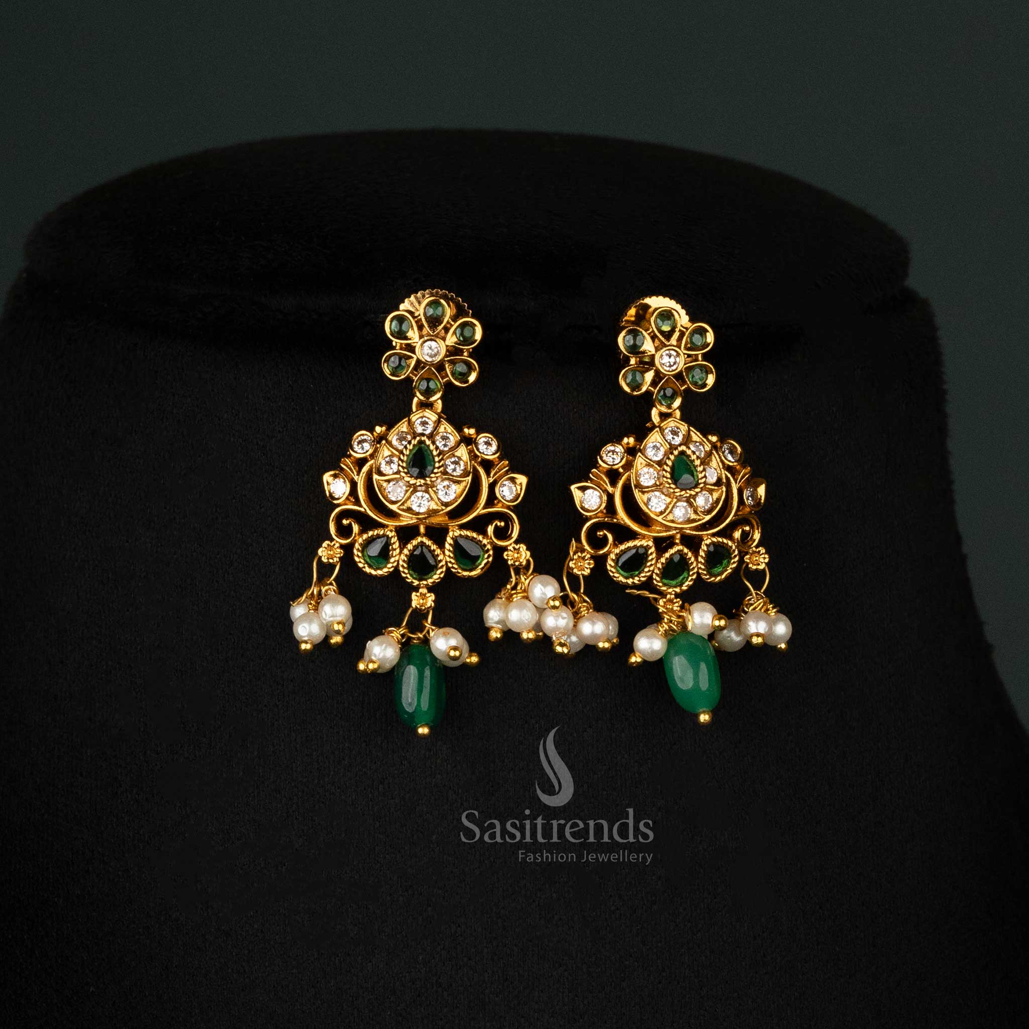 Elegant temple-style matte gold-plated earrings set with green stones and intricate floral motifs, ideal for bridal wear - Sasitrends