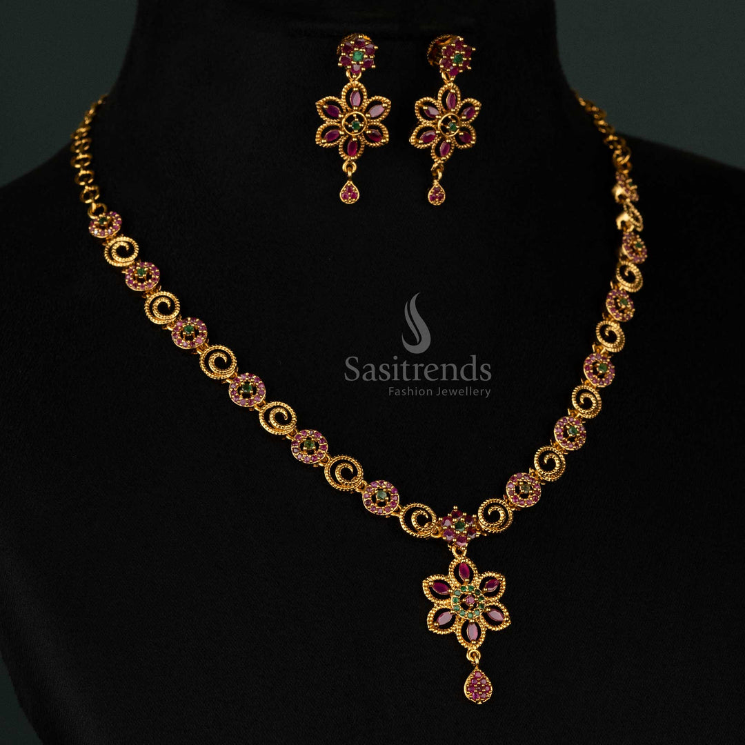 Exquisite matte gold plated floral swirl necklace set featuring shimmering ruby-green AD stones, a designer drop pendant, and detailed craftsmanship - Sasitrends