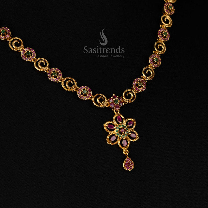 Intricate floral swirl matte gold plated necklace set decorated with dazzling ruby-green AD stones, an artistic drop pendant - Sasitrends