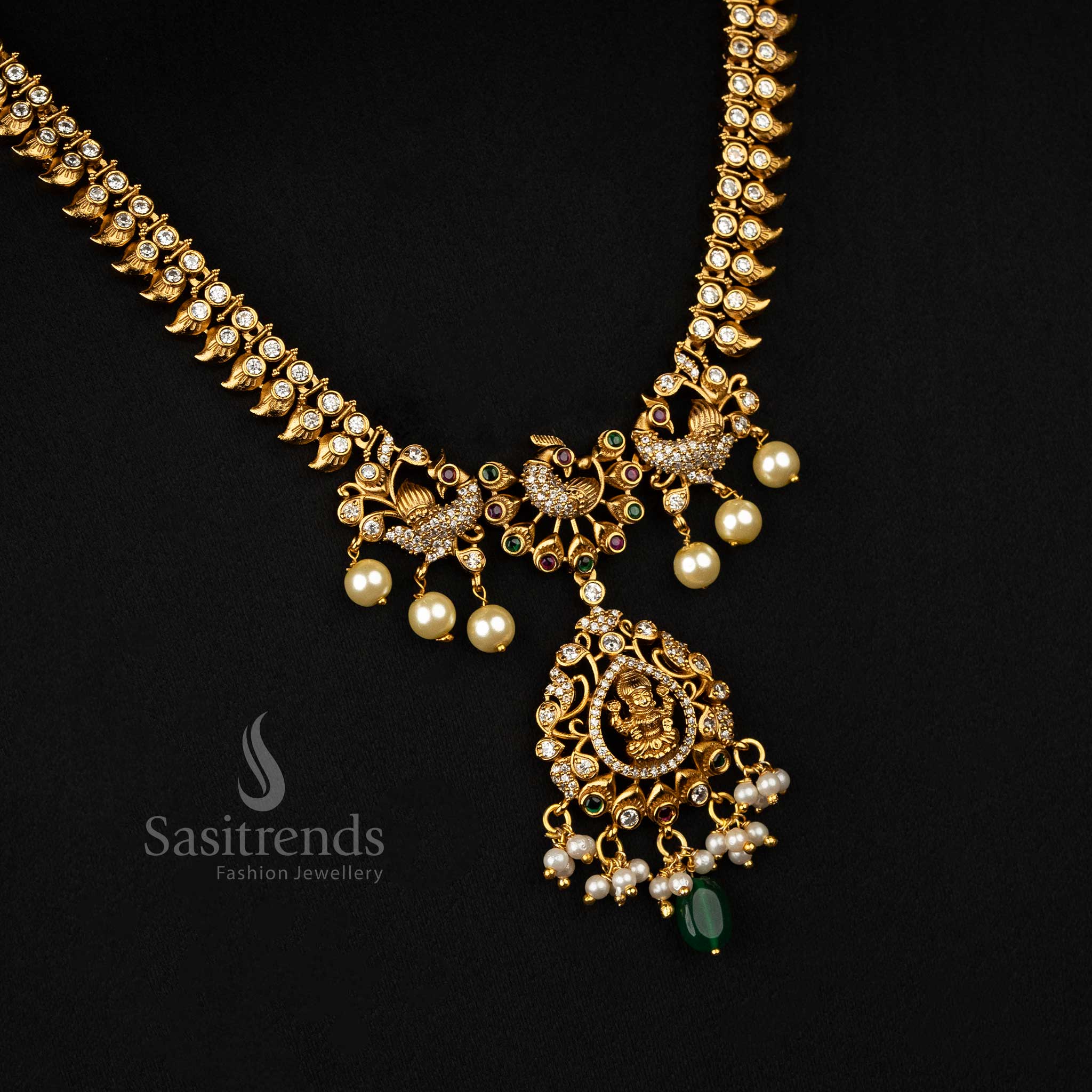 Ornamental matte gold-plated necklace set with ruby-green AD stones, peacock designs, and a traditional Lakshmi pendant - Sasitrends