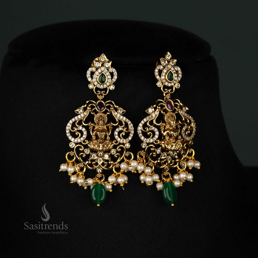 Elegant two-line matte gold-plated jewellery set with Lakshmi motifs, AD stones, peacock designs, and hanging pearls - Sasitrends