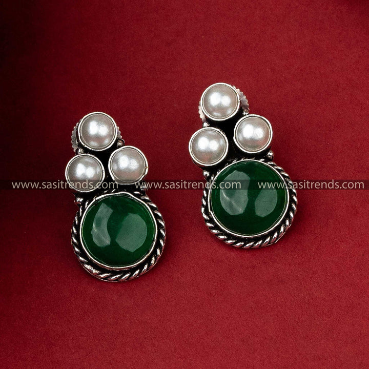 Oxidised silver earrings adorned with three pearls and a deep green monalisa stone, perfect for an elegant outfit.