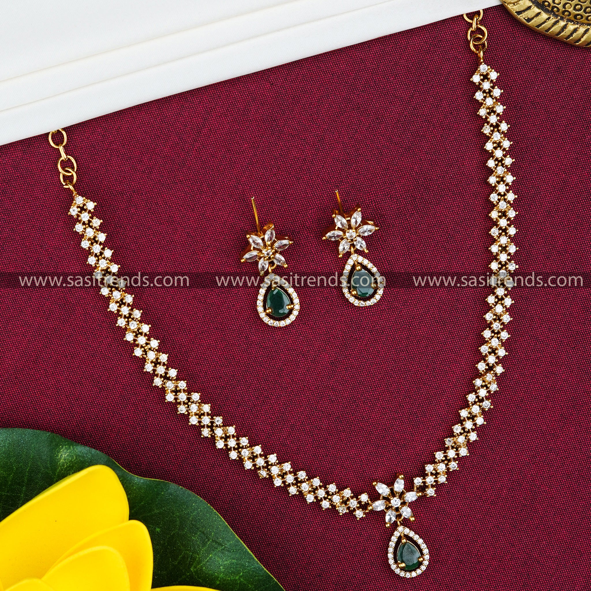 Party wear necklace set with green-colored tilak-shaped stone pendant, adorned with American diamond accents