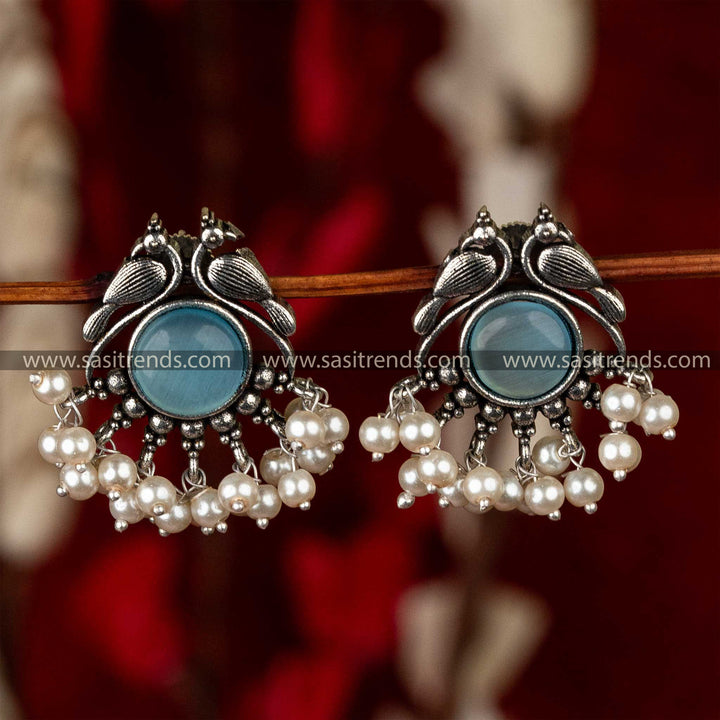 Sapphire-centered oxidised peacock earrings featuring a luxurious pearl drop