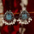 Sapphire-centered oxidised peacock earrings featuring a luxurious pearl drop