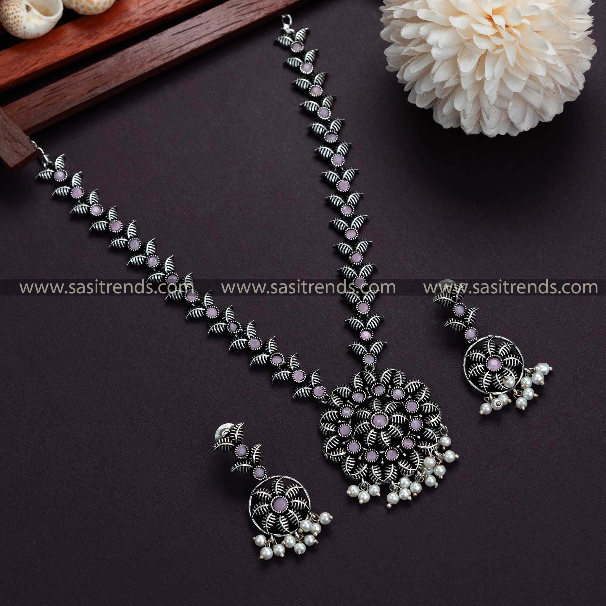 Express elegance with pink stones on this trendy Oxidised German Silver necklace and pearl earrings set