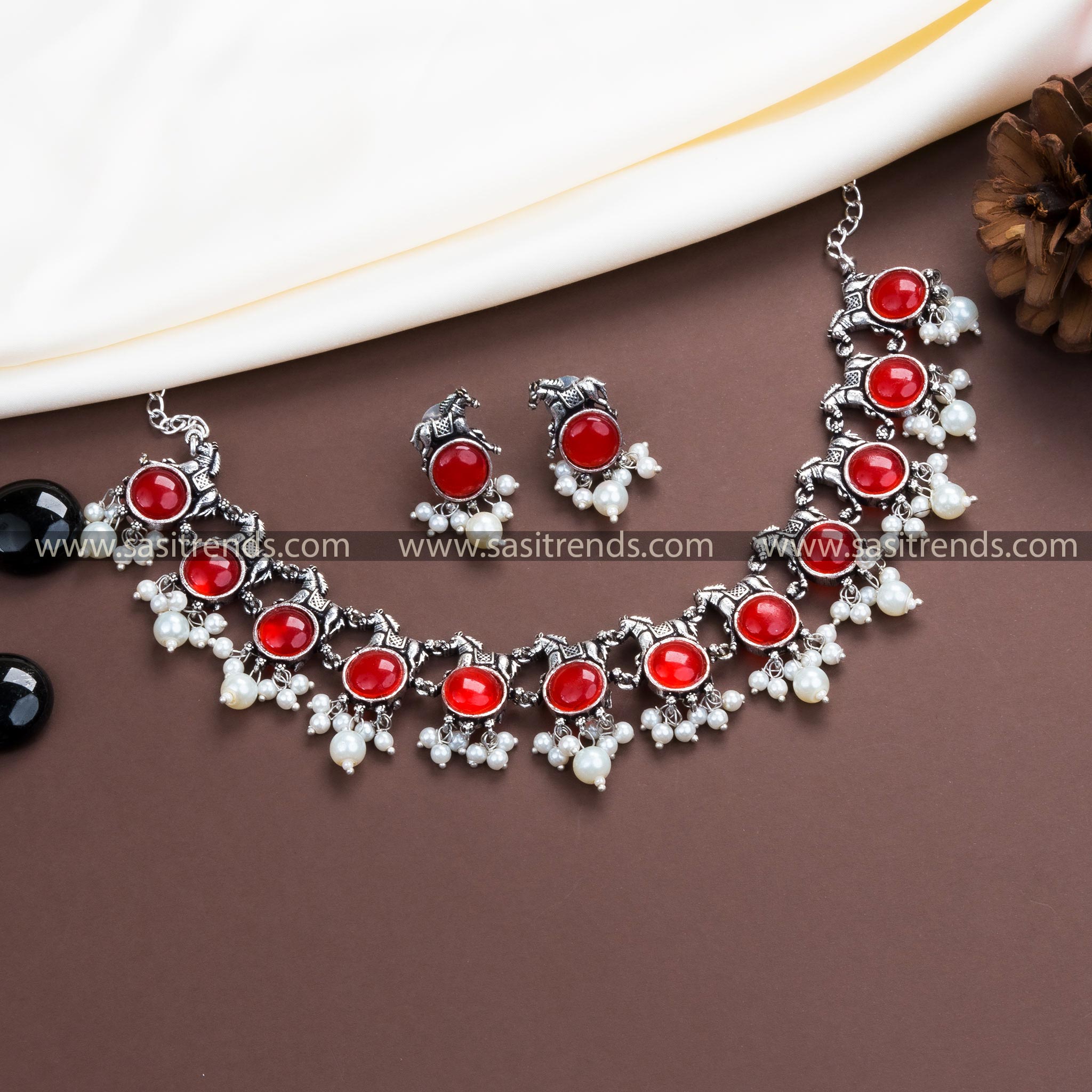 Sparkling Ruby Stones Highlight Our Oxidised German Silver Necklace with Pearl Horse Earrings.