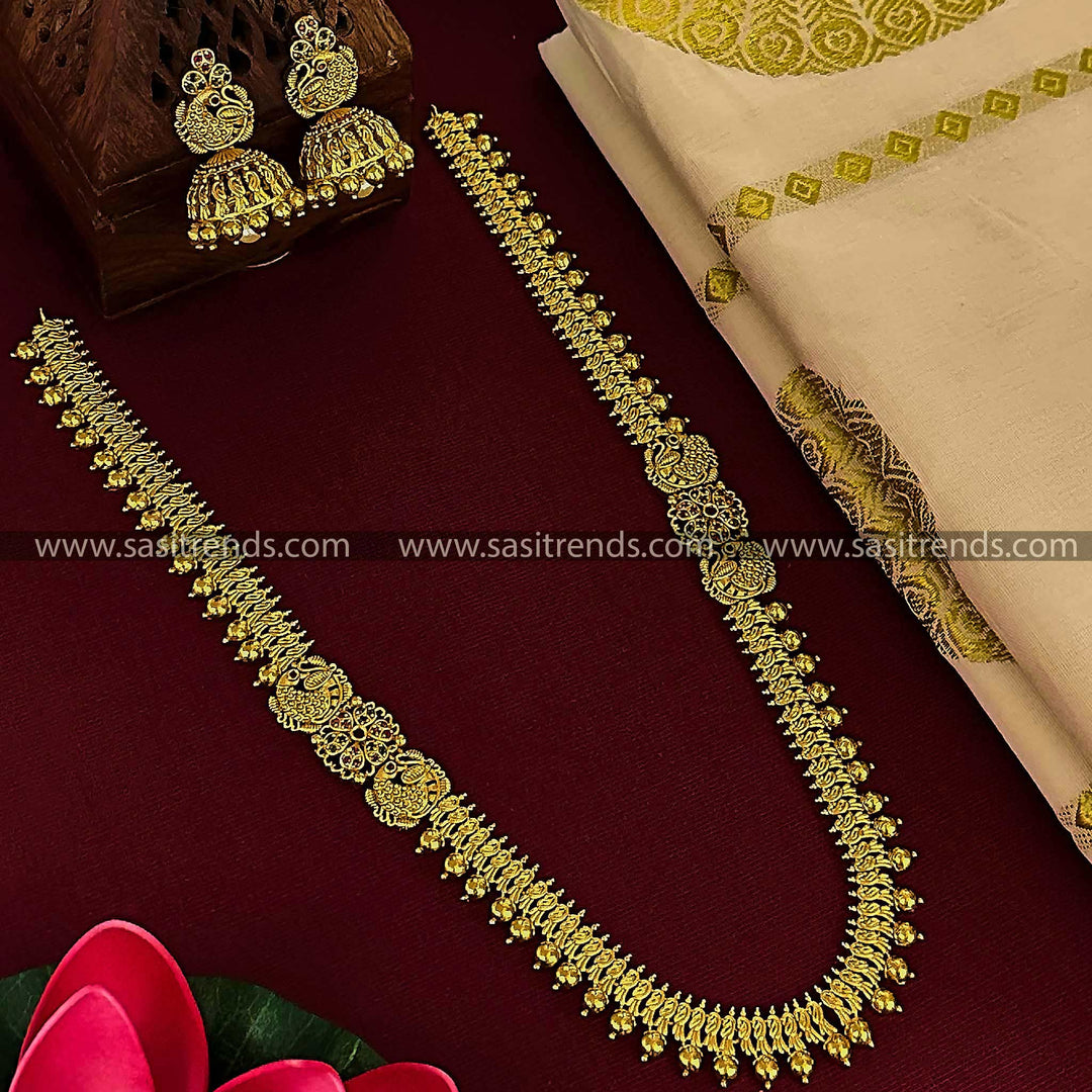 Matte gold plated long necklace set with peacock motifs and matching jhumkas for women.