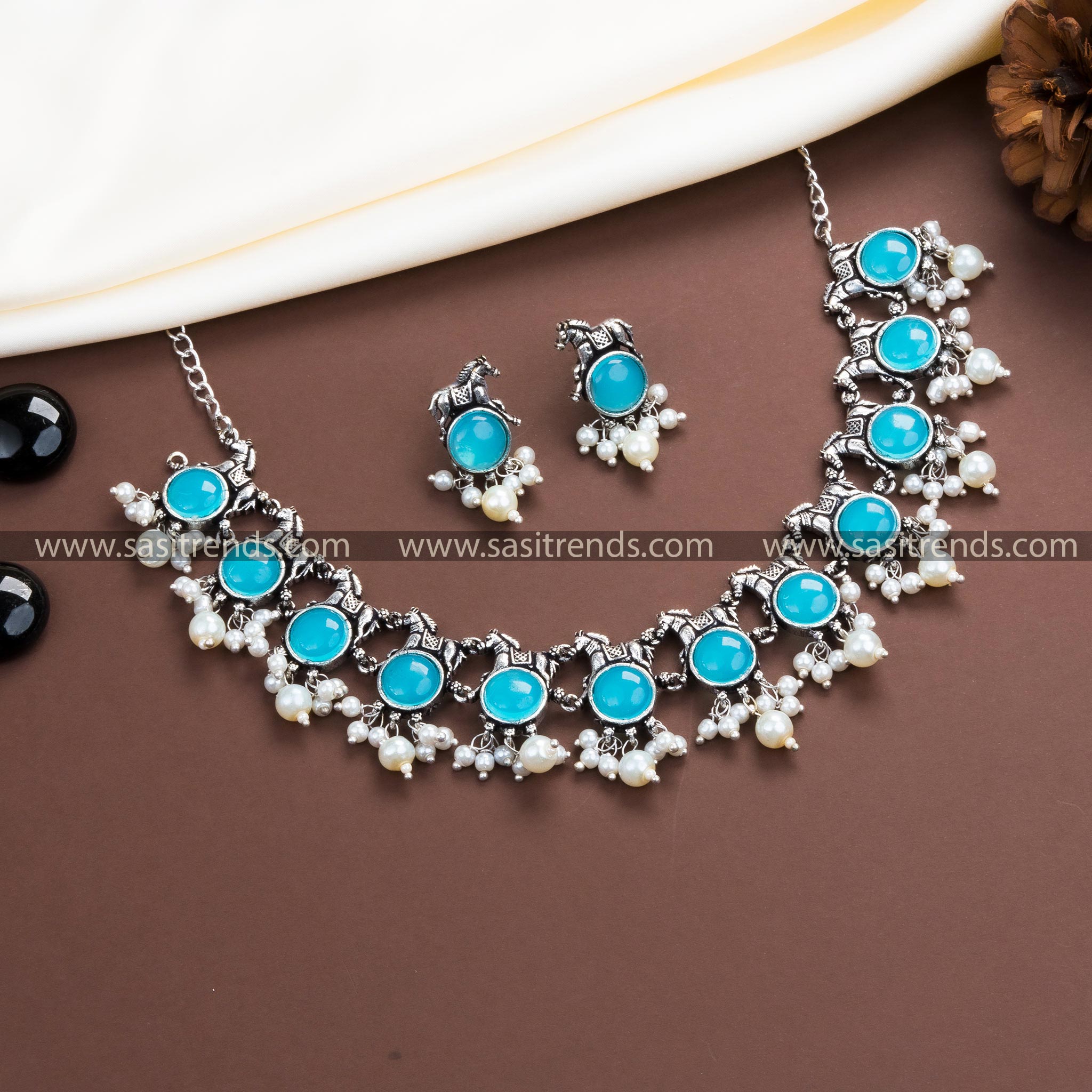 Enchanting Sky Blue Stone Embellishments on Our Trendy Oxidised German Silver Horse Necklace with Pearl Earrings.