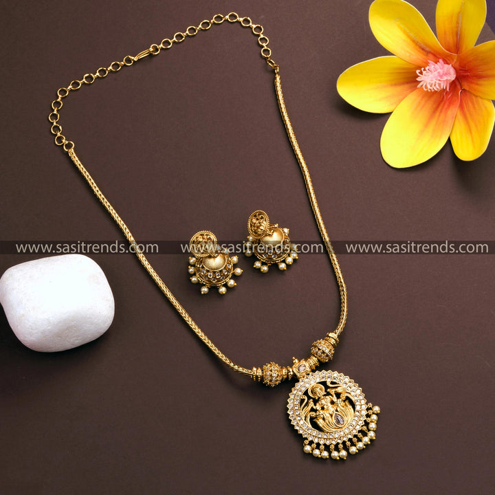 Matte gold plated Lakshmi pendant necklace with jhumkas, featuring white American diamond stones and pearl drops - Traditional Indian jewelry for women.