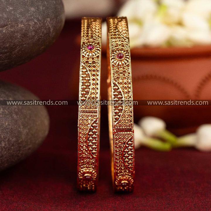 Antique matte gold bangles with geometric and floral motifs and ruby AD stones