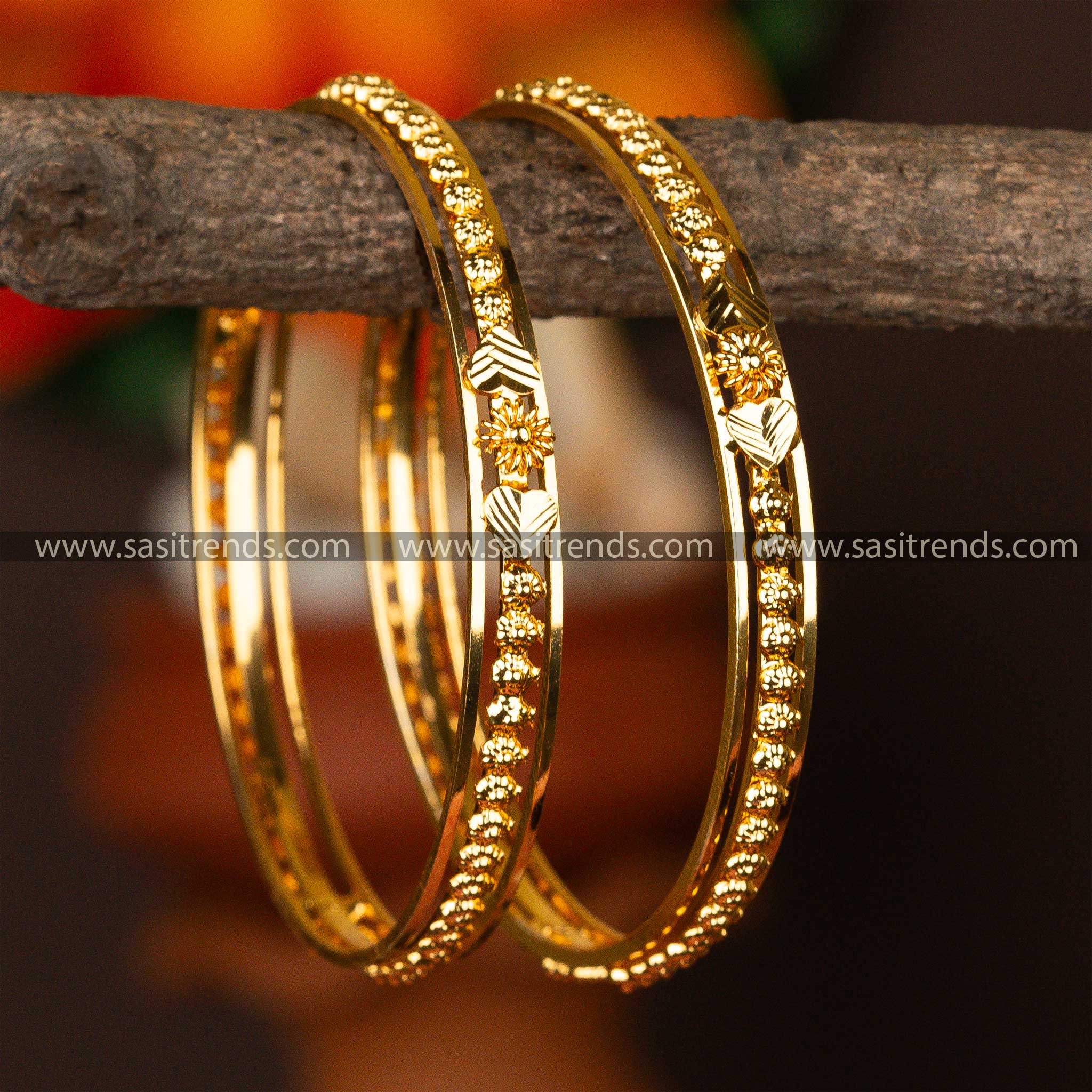 Dazzling micro gold-plated bangles with floral patterns, set against a warm backdrop.