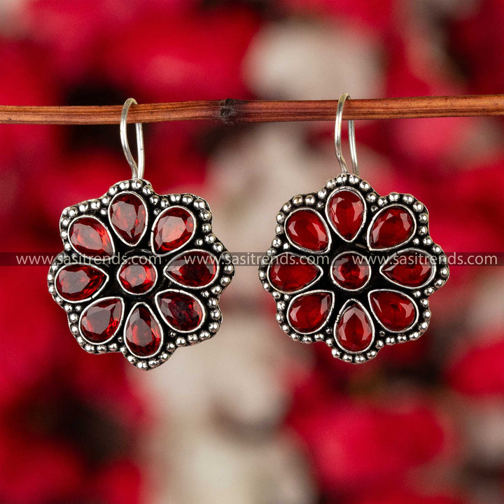 Ruby red stone-studded oxidized silver floral earrings