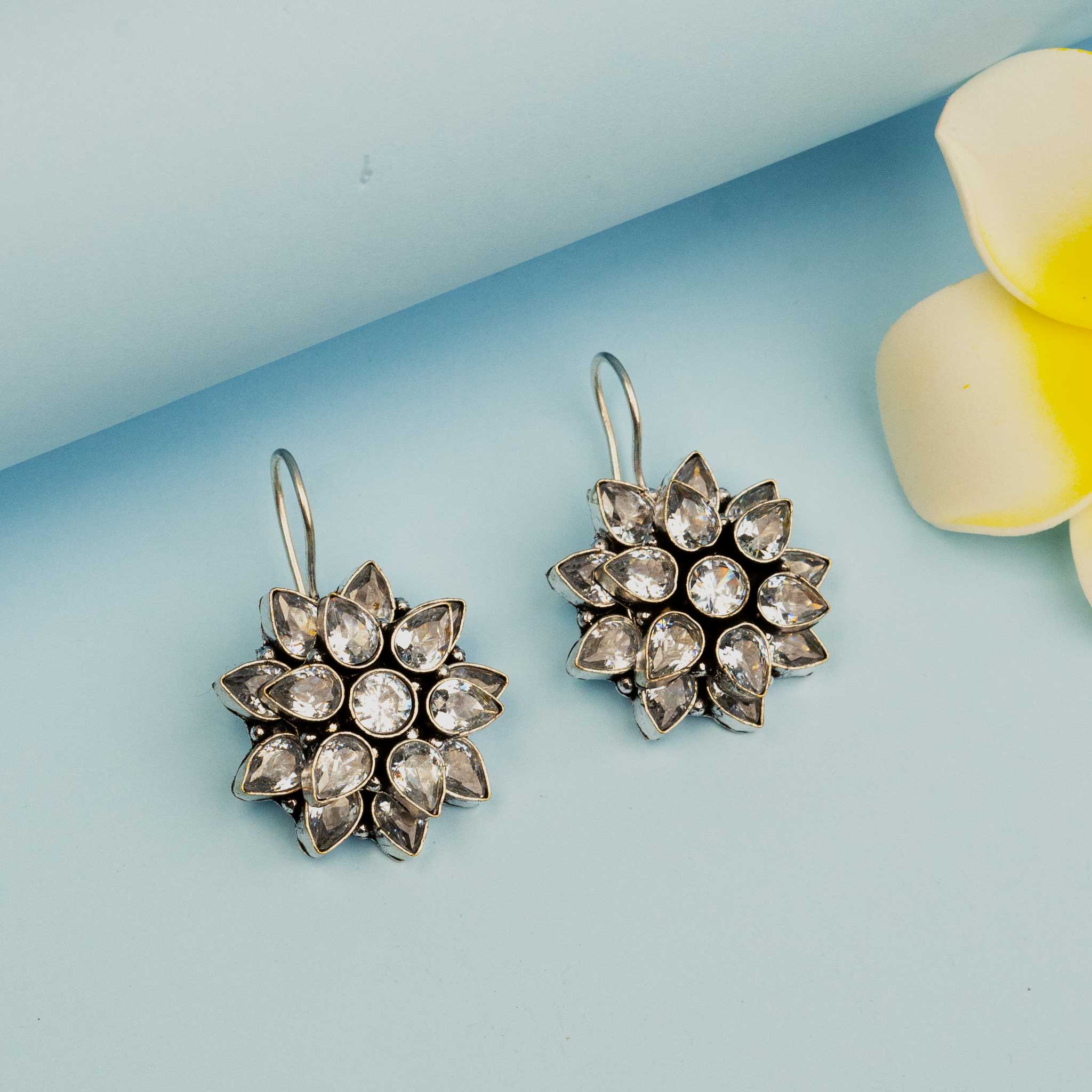 Trendy oxidised silver flower stud earrings with American Diamond stone.